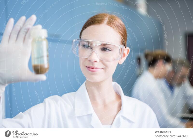 Smiling scientist in lab examining sample female scientists laboratory smiling smile checking examine science sciences scientific woman females women swatch