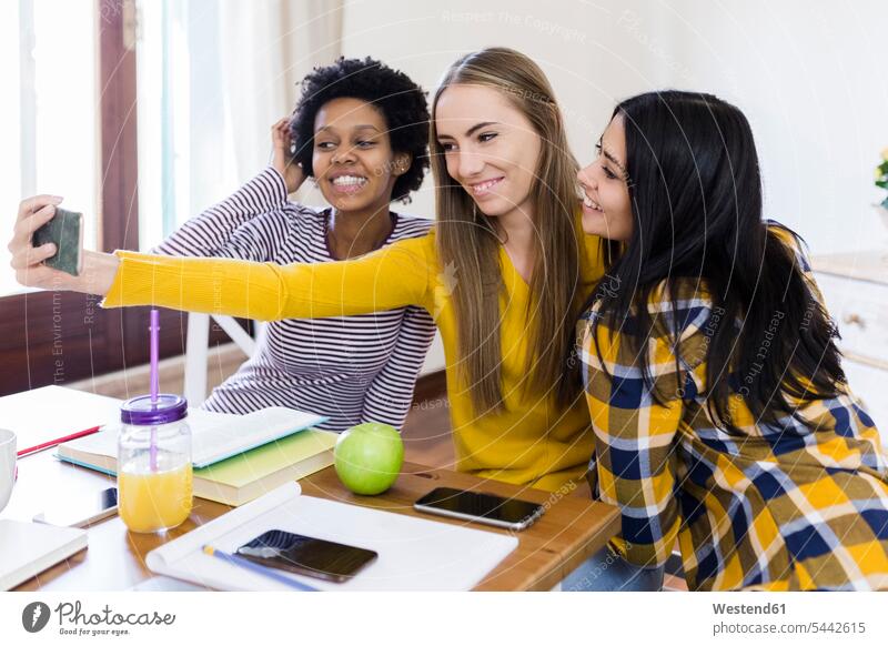 Group of female students taking selfie at table at home Selfie Selfies smiling smile Table Tables mobile phone mobiles mobile phones Cellphone cell phone