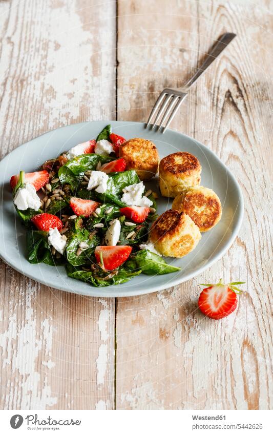 Plate of spinach salad with falafel, goat cheese, strawberries and sunflower seed dish dishes Plates prepared delicacy specialty specialties Goats Cheese hearty