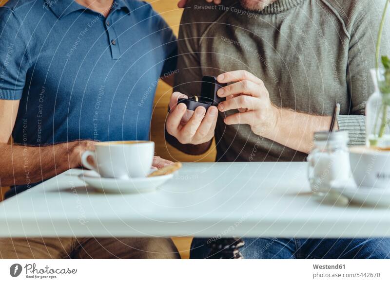 Close-up of gay couple with wedding ring in cafe gay men gay man homosexual men homosexual man marriage Love loving twosomes partnership couples marrying queer