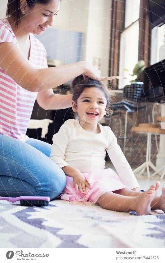 Mother doing her little daughter's hair ponytail pony-tail laughing Laughter hairdressing cute twee Cutie mother mommy mothers ma mummy mama daughters home