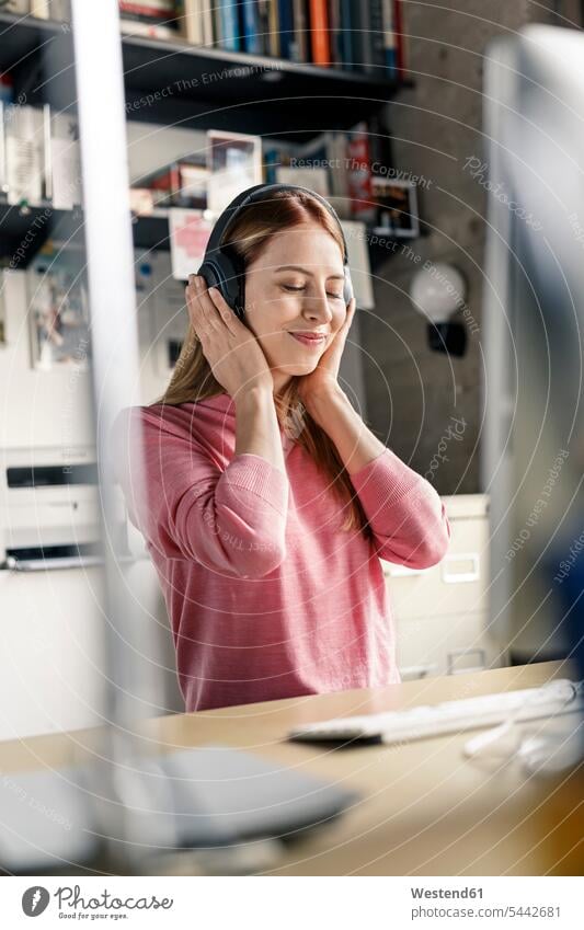 Portrait of young woman wearing headphones at desk at home females women portrait portraits headset desks Adults grown-ups grownups adult people persons