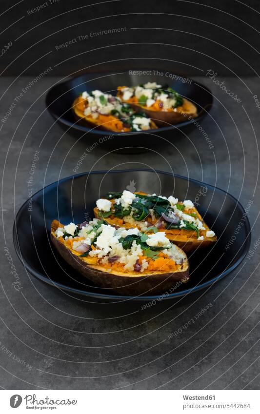 Filled sweet potato with spinach, red onion, couscous, feta and coriander Bowl Bowls prepared filled cilantro Coriandrum sativum garnished ready to eat