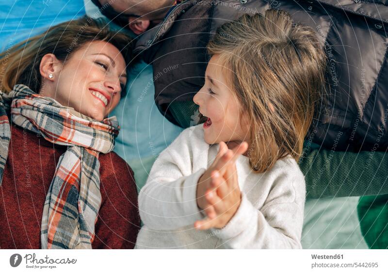 Happy girl with her family on blanket clapping hands lying laying down lie lying down relaxed relaxation happiness happy Blanket Blankets families smiling smile