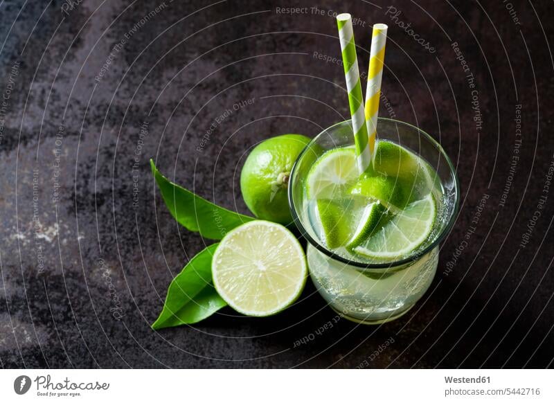 Fruit spritzer of limes in a glass with drinking straws organic organic edibles juicy healthy eating nutrition elevated view High Angle View High Angle Shot