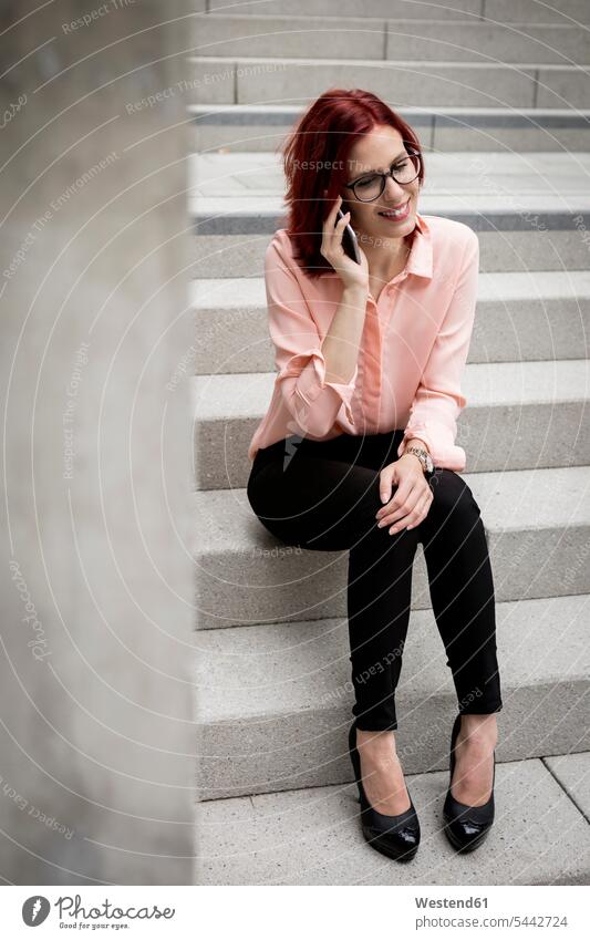Young businesswoman sitting on stairs, talking on the phone friendly nice young smart smart casual smart-casual Business Casual well dressed Smartphone iPhone