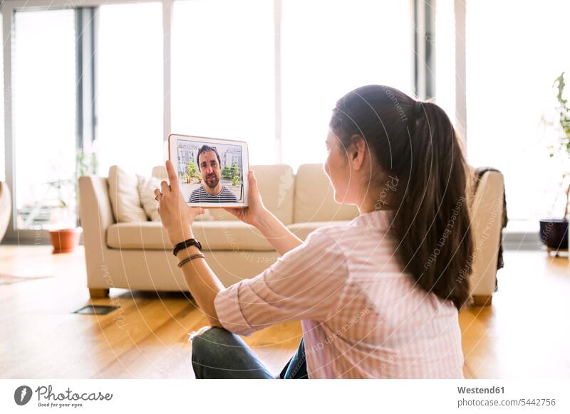 Young woman using tablet for video chat at home video chatting video messaging females women digitizer Tablet Computer Tablet PC Tablet Computers iPad