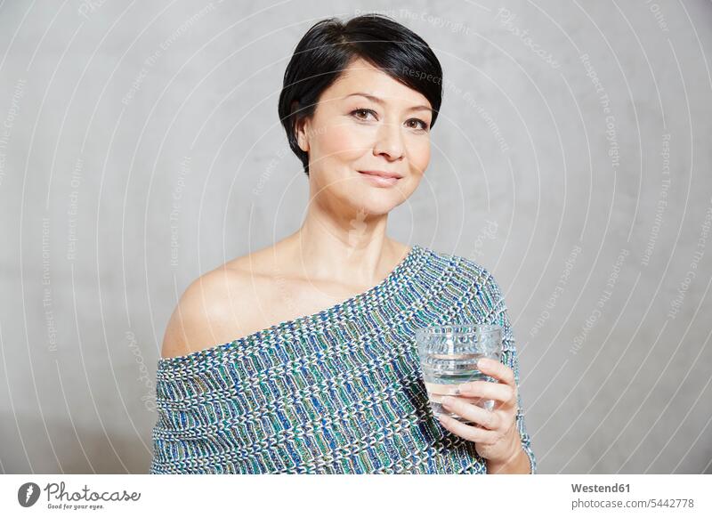 Portrait of confident woman holding glass of water Water females women Glass Drinking Glasses portrait portraits beverages Drinks Beverage food and drink