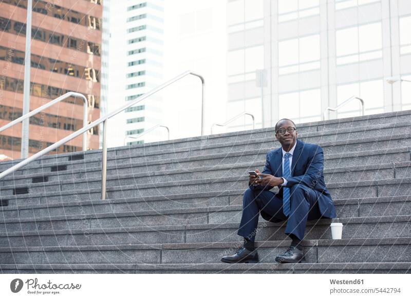 Businessman sitting on stairs with cell phone and takeaway coffee Coffee Business man Businessmen Business men stairway break mobile phone mobiles mobile phones