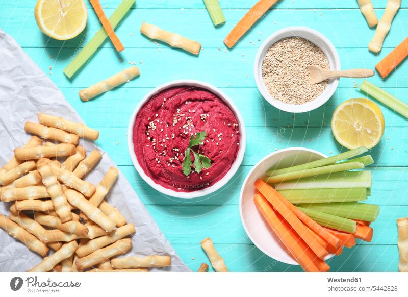 Bowl of beetroot hummus, sesame, carrot and celery crudites and breadsticks wooden spoon wooden spoons Breadstick Breadsticks Hummus sesame seeds Carrot Carrots