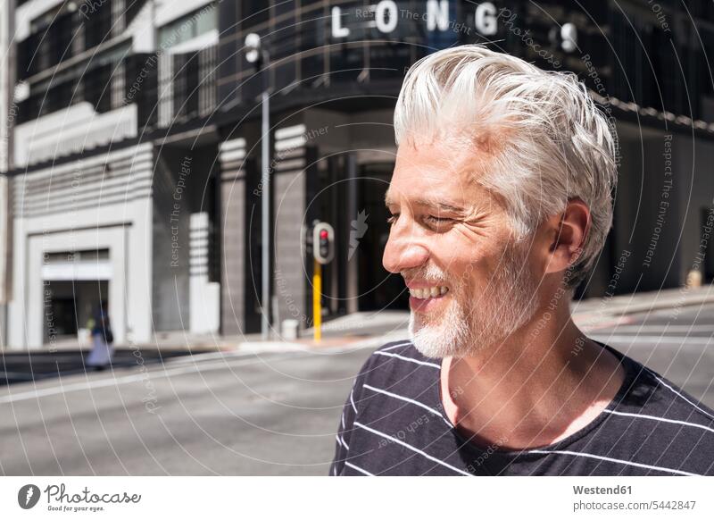 Portrait of a mature man, walking in the city men males on the move on the way on the go on the road carefree smiling smile portrait portraits beard Adults