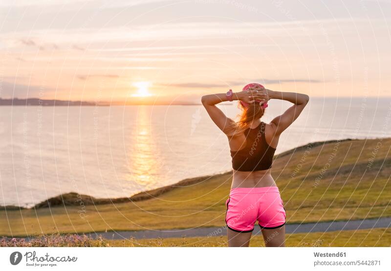 Young woman looking at the sea after workout females women exercising exercise training practising Adults grown-ups grownups adult people persons human being