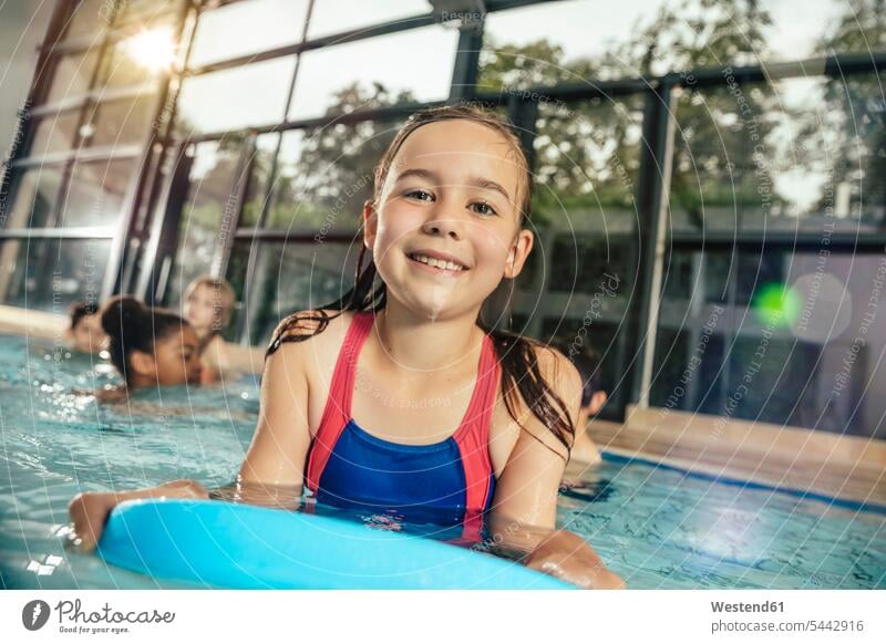 Portrait of smiling girl with friends in indoor swimming pool swimming bath smile indoor swimming pools portrait portraits females girls friendship child
