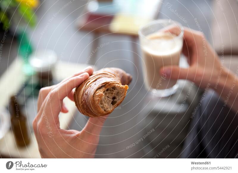 Man's hands holding croissant and glass of Latte Macchiato eating Croissant Croissants Cornetto Cornettos Pastry Pastries Sweet Food sweet foods food and drink