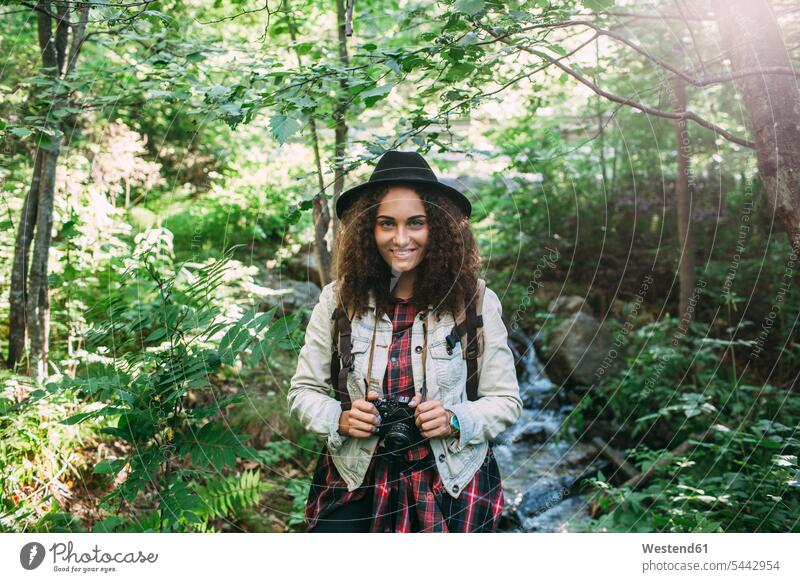 Portrait of smiling teenage girl with camera in nature portrait portraits forest woods forests Teenage Girls female teenagers Teenager Teens people persons