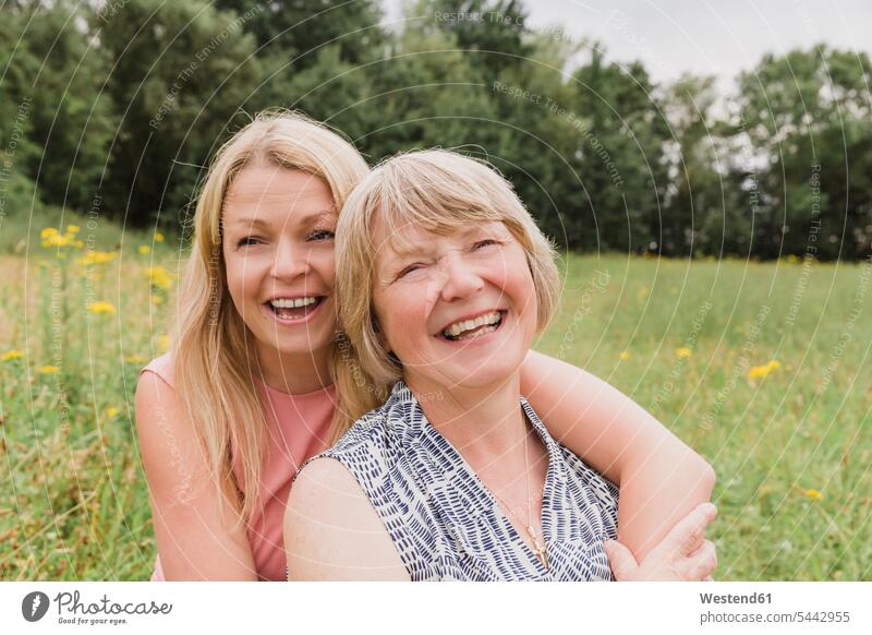 Portrait of mother and adult daughter having fun on a meadow laughing Laughter portrait portraits mommy mothers ma mummy mama daughters positive Emotion Feeling