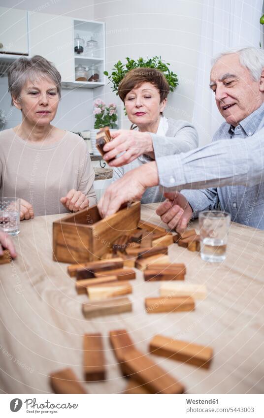 Group of seniors having a games evening at home senior adults old dexterity game game of skill dexterity games games of skill happiness happy building playing