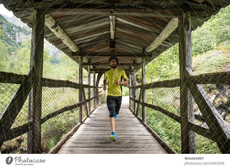 Italy, Alagna, man running on wooden bridge in the mountains men males Jogging athlete Sportspeople Sportsman Sportsperson athletes Sportsmen Adults grown-ups