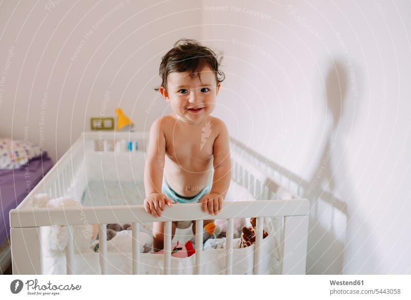 Portrait of happy baby girl in crib baby cot baby crib Cot children's bed portrait portraits infants nurselings babies beds people persons human being humans