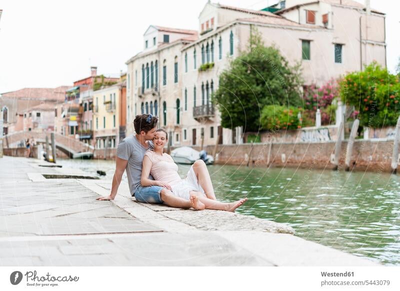 Italy, Venice, couple in love relaxing at canal twosomes partnership couples people persons human being humans human beings smiling smile happiness happy