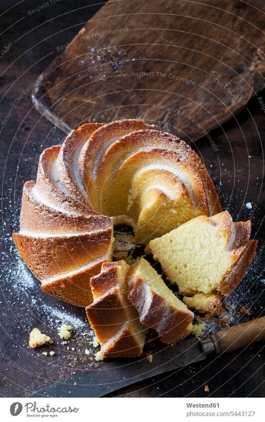 Sliced Gugelhupf sprinkled with icing sugar nobody Ring Cake Bundt Cake Ring Cakes Bundt Cakes baked Baked Food prepared copy space crumbs knife knives