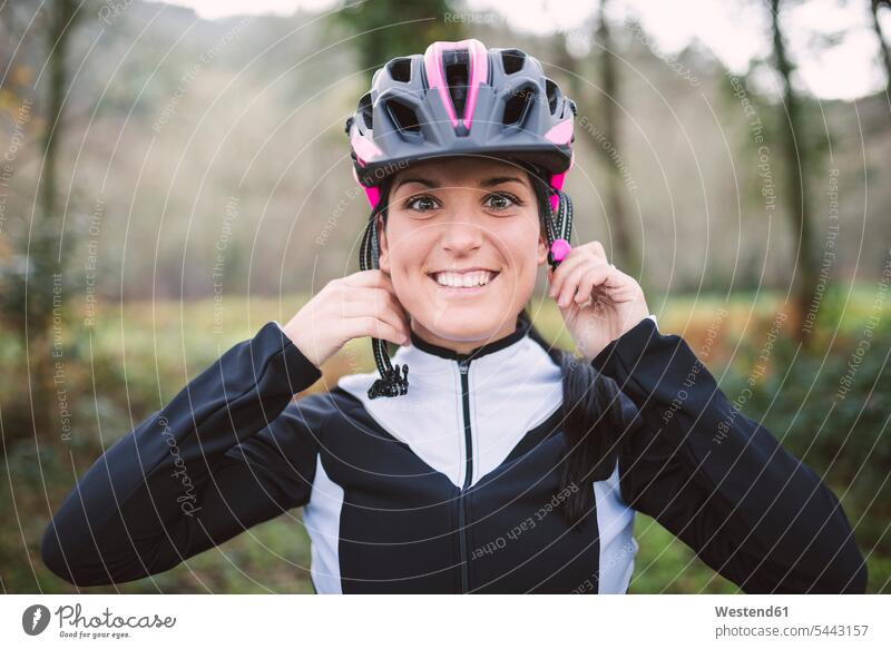 Portrait of smiling woman putting on bicycle helmet cycling helmet Bike Helmet bicycle helmets cycling helmets Cycle Helmet Cycle Helmets smile mountain biking