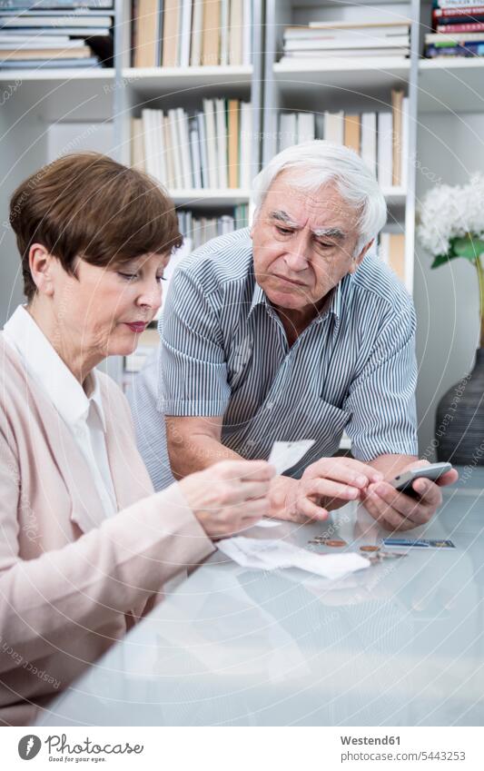 Senior couple with bills and calculator checking their expenses worried worries Expense Test testing Check senior adults seniors old Control controlling costs