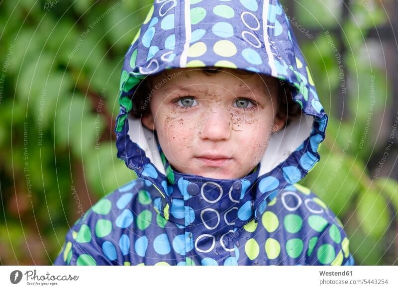 Portrait of little boy with dirty face wearing hooded jacket in rain hoods boys males portrait portraits child children kid kids people persons human being