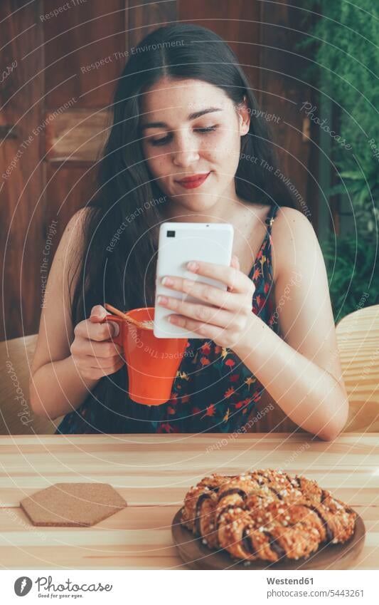 Freckled young woman with coffee mug using smartphone photographing Selfie Selfies females women Adults grown-ups grownups adult people persons human being