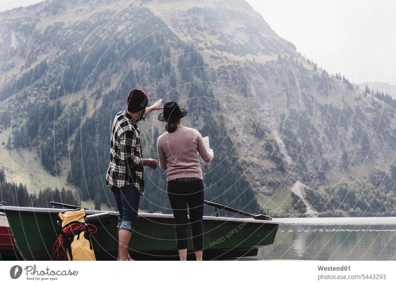 Austria, Tyrol, Alps, couple with map standing at mountain lake lakes twosomes partnership couples water waters body of water people persons human being humans