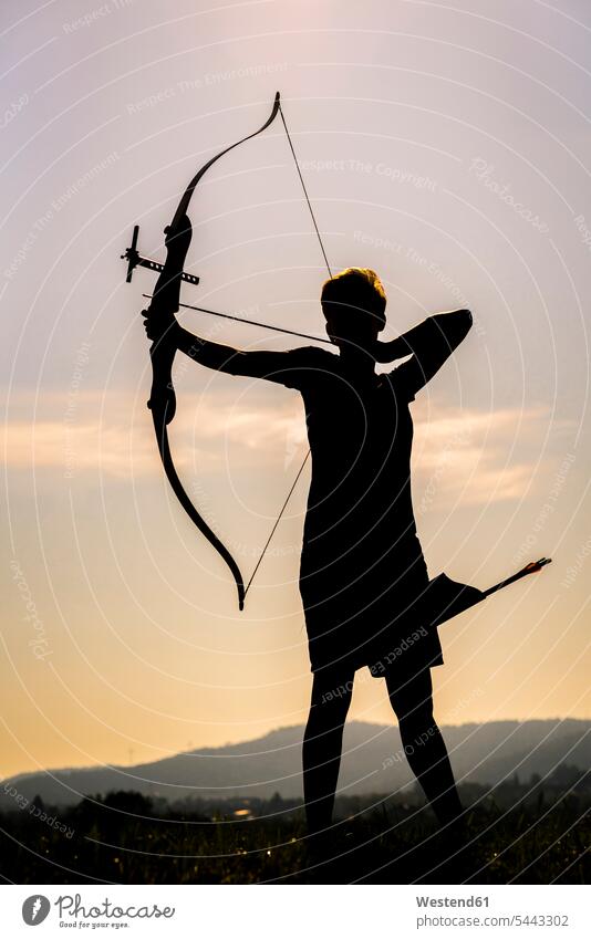 Silhouette of an archeress at twilight archery woman females women arrow arrows shooting sports Adults grown-ups grownups adult people persons human being