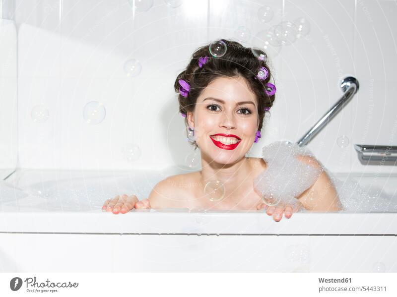 Portrait of smiling young woman with curlers in bath portrait portraits bathing bathe Taking A Bath Bubble Bath Foam Baths Bubble Baths Curler Hair Rollers