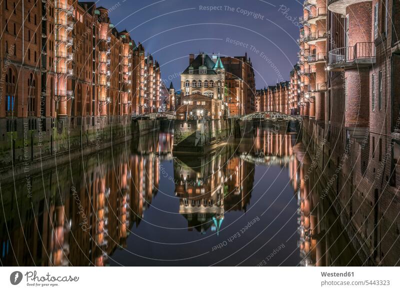 Germany, Hamburg, Speicherstadt, lighted old buildings with Elbe Philharmonic Hall in the background cloud clouds evening light water reflection