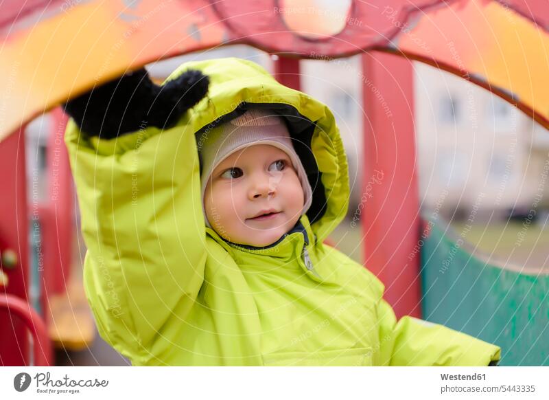 Toddler with rain jacket on playground portrait portraits boy boys males play yard play ground playgrounds happiness happy child children kid kids people