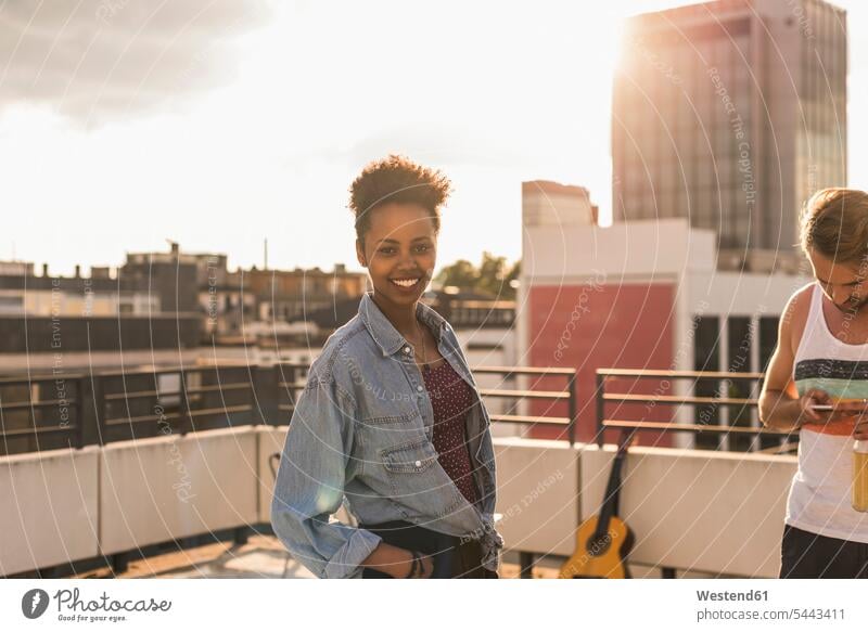 Portrait of smiling young woman on a rooftop party Party Parties celebrating celebrate partying guitar guitars couple twosomes partnership couples Beer Beers