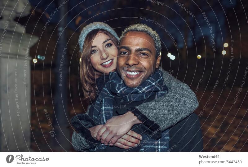 Portrait of happy young couple in front of park portrait portraits twosomes partnership couples people persons human being humans human beings winter hibernal
