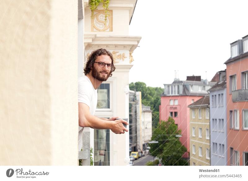 Portrait of smiling man with coffee mug on balcony men males portrait portraits balconies Adults grown-ups grownups adult people persons human being humans