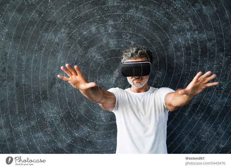 Mature man wearing VR glasses reaching out with hands t-shirt tee-shirt T- Shirt t-shirts looking through Looking Through Object Looking Through an Object