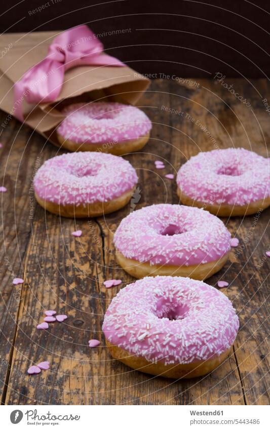 Doughnuts with pink icing and sugar granules on wood food and drink Nutrition Alimentation Food and Drinks sugar icing frosting baking decor sweet Sugary sweets