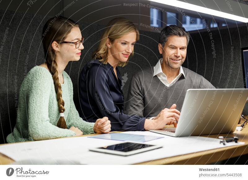 Colleagues sharing laptop in meeting box Laptop Computers laptops notebook colleagues smiling smile business people businesspeople office offices office room
