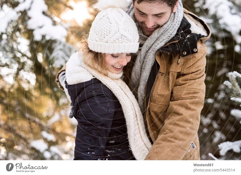 Happy young couple in snow-covered winter forest twosomes partnership couples people persons human being humans human beings laughing Laughter hibernal positive