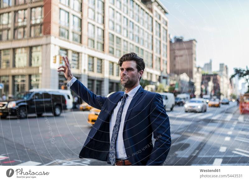 Businessman in the streets of Manhattan hailing a cab attractive beautiful pretty good-looking Attractiveness Handsome waving wave on the phone call telephoning