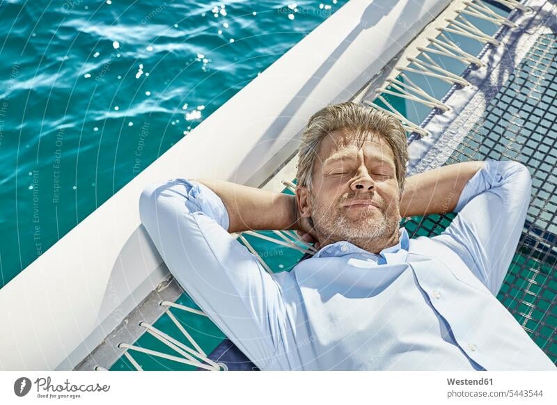 Portrait of mature man relaxing on his motor yacht men males motor yachts Adults grown-ups grownups adult people persons human being humans human beings Yacht
