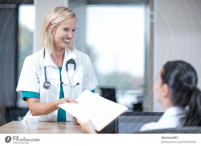 Doctor taking patient's record from receptionist clinic hospitals Medical Clinic nurse nurses medical chart medical file patient's records doctor physicians