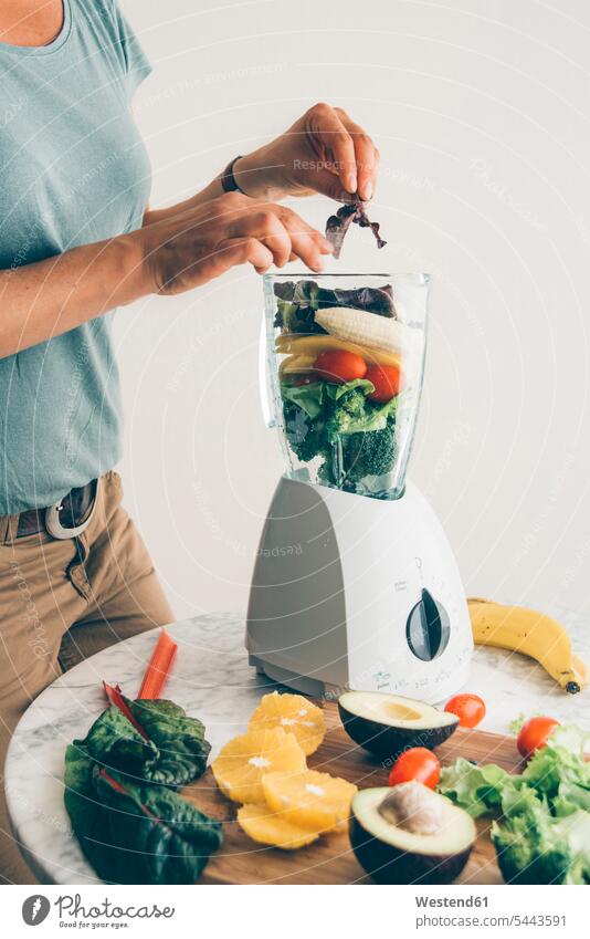 Woman filling fruit and vegetable into blender woman females women smoothie Smoothies Adults grown-ups grownups adult people persons human being humans