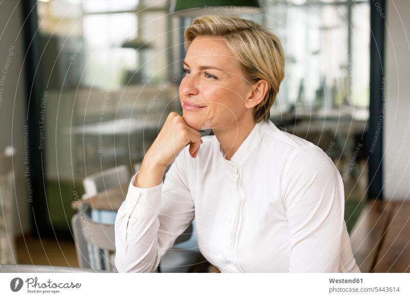 Portrait of confident blond woman looking sideways businesswoman businesswomen business woman business women portrait portraits thinking smiling smile females