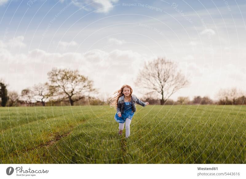 Smiling girl running on a field females girls Field Fields farmland child children kid kids people persons human being humans human beings fast quick speediness