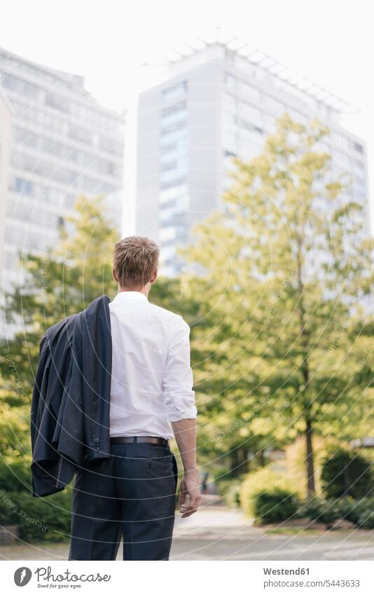 Rear view of businessman looking at office buildings Businessman Business man Businessmen Business men business people businesspeople business world