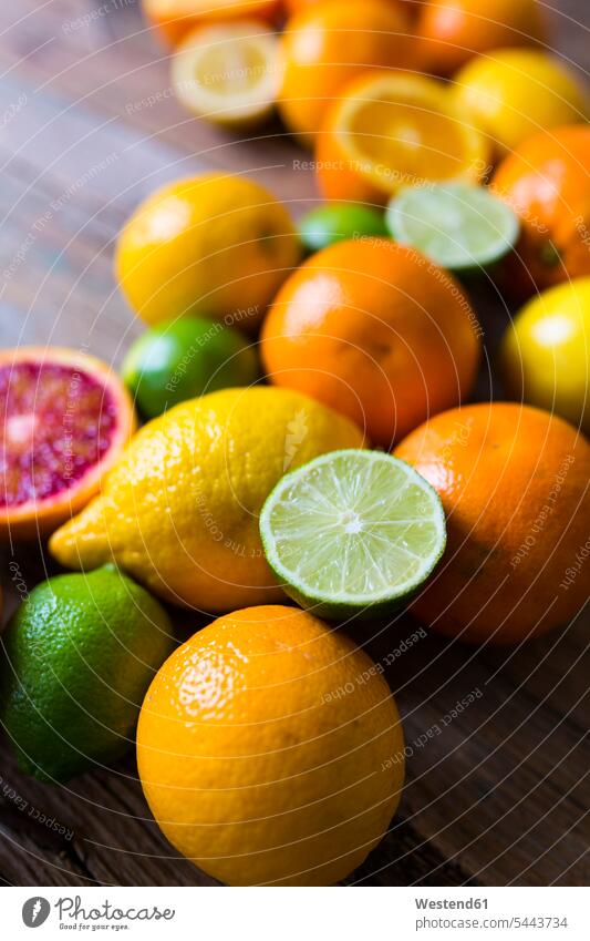 Sliced and whole limes, oranges and lemons on wood food and drink Nutrition Alimentation Food and Drinks Lime Lime Fruit Lime Fruits Limes abundance Plentiful