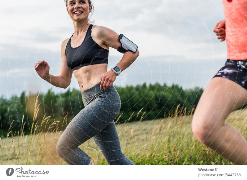 Two women running in the countryside smiling smile Jogging woman females female friends fitness sport sports Adults grown-ups grownups adult people persons